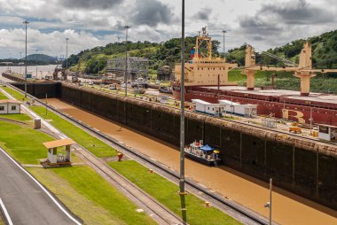 Bilgi Şehri, Panama - 30 Kasım 2008 Miraflores kilitleri. Çift kilit çalışıyor ve içinden bir gemi geçiyor. Ağır bulutlu arazi, biraz yeşil çimen ve kahverengi su..