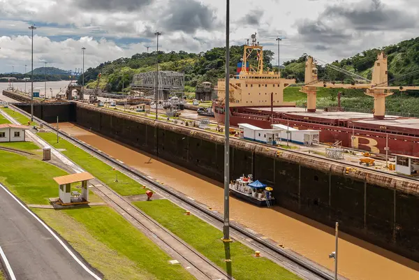 Bilgi Şehri, Panama - 30 Kasım 2008 Miraflores kilitleri. Çift kilit çalışıyor ve içinden bir gemi geçiyor. Ağır bulutlu arazi, biraz yeşil çimen ve kahverengi su..