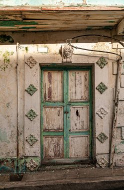 Panama Şehri, Panama - 30 Kasım 2008: Bej duvarlı harap olmuş bej-yeşil kapı ve tarihi şehir merkezinin caddesinde duvar resmi heykeller..