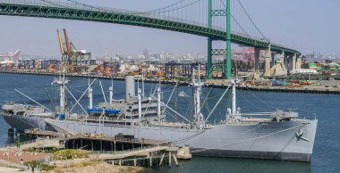 Los Angeles, ABD - 20 Nisan 2008 San Pedro Limanı. Gri Geçit Zaferi gemisi yukarıdaki yeşil süspansiyonlu Vincent Thomas Köprüsü 'ne yanaştı. Hepsi mavi gökyüzünün altında. Binalar, iskele vinçleri, konteynır yığınları.