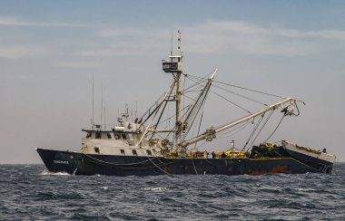 Cabo San Lucas, Meksika - 22 Nisan 2008: Açık mavi bulutların altındaki gri-mavi okyanus sularında siyah-beyaz Ensenada balıkçı teknesine yakın çekim.