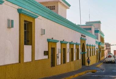 Mazatlan, Meksika - 23 Nisan 2008: Tarihi askeri hastane cepheli Streetview. Açık mavi gökyüzünün altında bej, gök mavisi ve hardal rengi duvarlar.