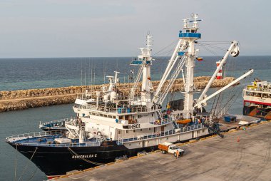 Manta, Ekvador - 2 Aralık 2008: Siyah ve Beyaz Esmeralda 'nın Kapanışı. Balıkçı teknesi yanaştı. Arkadaki gri su okyanusu. Kahverengi beton iskelede insanlarla dolu bir kamyonet..