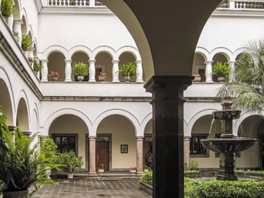 Quito, Ekvador - 2 Aralık 2008: Yeşil yapraklı iç avlu ve Başkanlık Carondelet Sarayı çeşmesi. Sütunlu beyaz duvarlar.