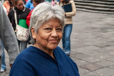 Quito, Ekvador - 2 Aralık 2008: Şehir merkezi tarihi. Gülümseyen ve mavi yelekli gri kadının yakın çekimi..