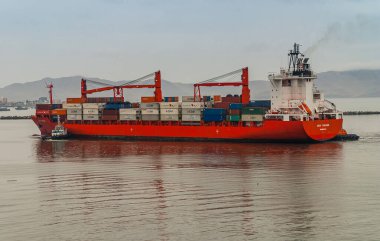 Lima, Peru - 4 Aralık 2008: Kırmızı CSAV Chicago konteynır gemisi Puerto Nuevo 'ya tamamen açık mavi gökyüzü altında girdi. Ufuktaki dağlar, kahverengi sular..