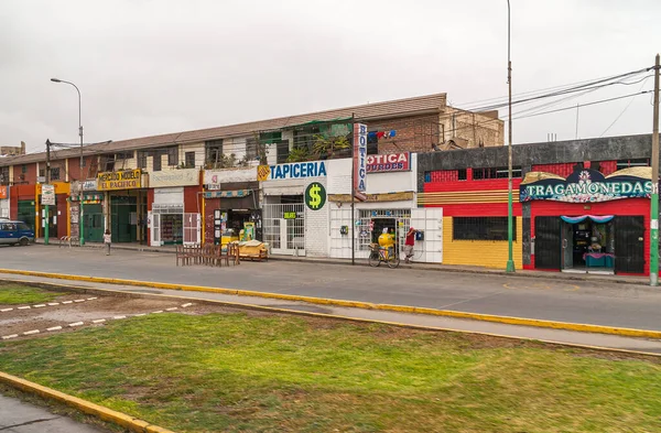 2008年 平成20年 12月4日 ペルー リマ市 銀の空の下 緑の芝生を前に2本の路線を結ぶ スロットマシンカジノ ドラッグストアなどの顔や名前の看板の色 — ストック写真