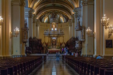 Lima, Peru - 4 Aralık 2008: Katedral 'deki nave' den Chancel 'deki ana sunak görüntüsü. Kenarlarında siyah ahşap banklar var. Heykelleri, ışıkları ve insanları olan sütunlar.