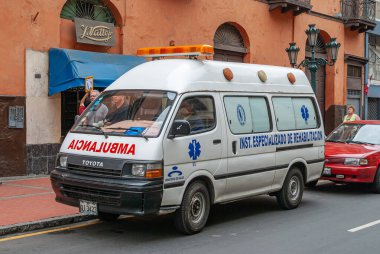 Lima, Peru - 4 Aralık 2008: Caddede beyaz ambulans minibüsü kapatıldı. Arkaplan olarak turuncu-kahverengi cephe. 