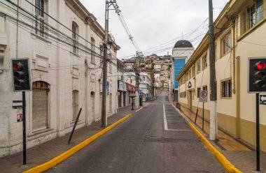 Coquimbo, Şili - 7 Aralık 2008: Sabahın erken saatlerinde gümüş gökyüzü altında her iki tarafında konutları ve kapalı işletmeleri olan boş bir sokak üretiyor.
