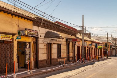 La Serena, Şili - 7 Aralık 2008: Şehir merkezinde, çağrı ve internet merkeziyle barların, restoranların ve küçük dükkanların komşusu. Açık mavi gökyüzü. Sokakta sarımsı cepheler.