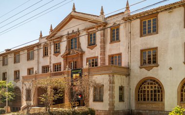 La Serena, Şili - 7 Aralık 2008: şehir merkezi. Bölge için eğitim otoritesi binası açık mavi gökyüzünün altında bej-kahverengi taş bir bina. Biraz yeşil yaprak..