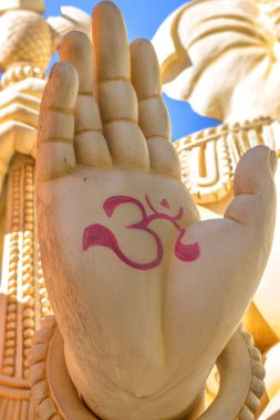 Bengaluru, Karnataka, India - October 6, 2013: Shivoham Shiva Temple. Hand closeup of Ganesha giant statue. Here, Vighnaharan is his nickname. Figure 3 symbol is the Om symbol.