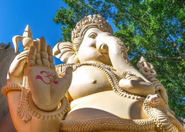 Bengaluru, Karnataka, India - October 6, 2013: Shivoham Shiva Temple. 32 foot statue of Ganesha: bust and hand closeup. Here, Vighnaharan is his nickname. Figure 3 symbol is the Om symbol