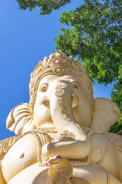 Bengaluru, Karnataka, Hindistan - 6 Ekim 2013: Shivoham Shiva Tapınağı. Mavi gökyüzüne ve yeşil yapraklara karşı dev Ganesha heykelinin yakın çekimi. Kobra kafası görüntüde. İşte, Vighnaharan onun lakabı..