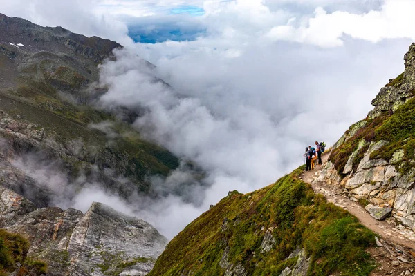 Drei Backpacker stehen Bergpfad Blick auf schöne v — Stockfoto