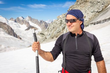 Dağcı alpinist poz buz baltası aracı tutarak.