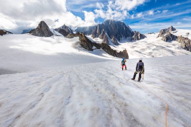 Couple alpinists mountaineers walking glacier  slopes. Mont Blan clipart