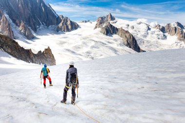 Couple alpinists mountaineers walking glacier  slopes. Mont Blan clipart
