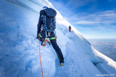 Two alpinists mountaineers climbing over ice crevasse. clipart