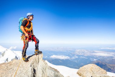 Alpinist dağcı ayakta kaya uçurum dağ zirvesi. 