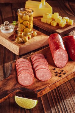 Peynir ve zeytin parçalarıyla dilimlenmiş füme salam.