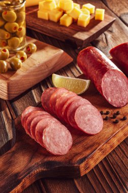 Peynir ve zeytin parçalarıyla dilimlenmiş füme salam.