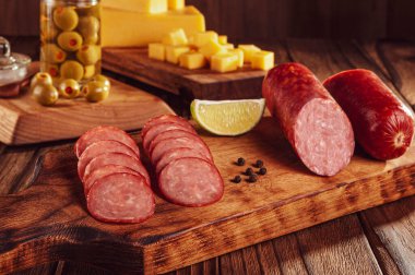 Peynir ve zeytin parçalarıyla dilimlenmiş füme salam.