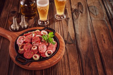 Dilimlenmiş kızarmış kalamar sosisi soğan ve birayla Brezilya mezesi ve uzay kopyası.