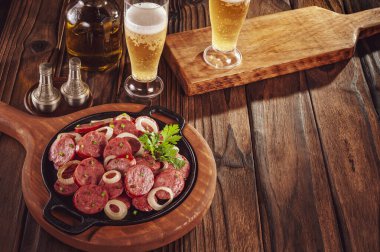 Dilimlenmiş kızarmış kalamar sosisi soğan ve birayla Brezilya mezesi ve uzay kopyası.