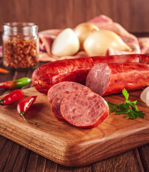 Ahşap bir masada, içinde malzemeler olan dilimlenmiş sosis.