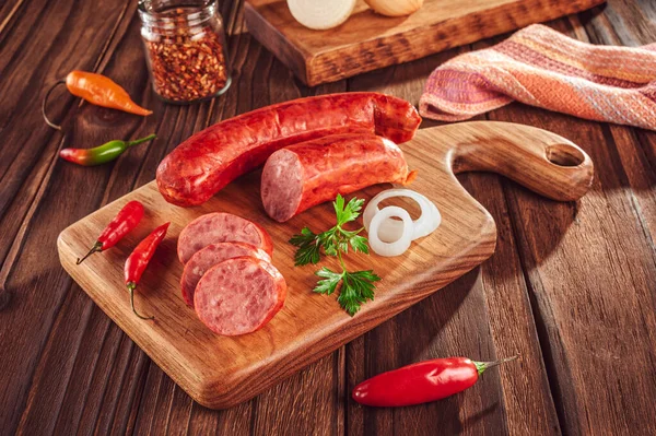 Ahşap bir masada, içinde malzemeler olan dilimlenmiş sosis.