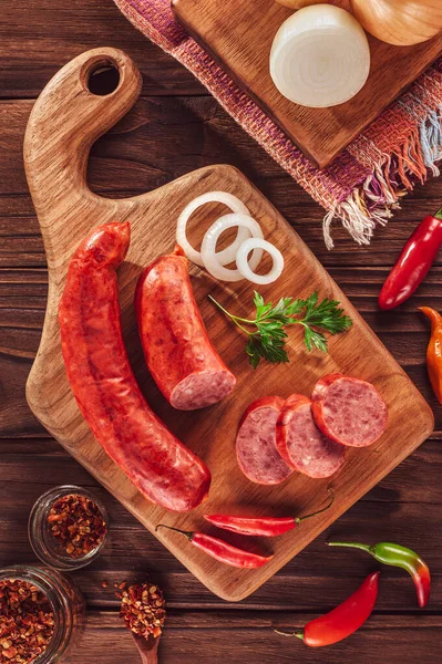 Ahşap bir masada, içinde malzemeler olan dilimlenmiş Calabrese sosisi