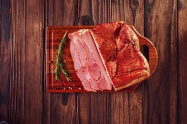 Biberiye dallı taze domuz pastırması ve ahşap arka planda izole edilmiş baharatlar.