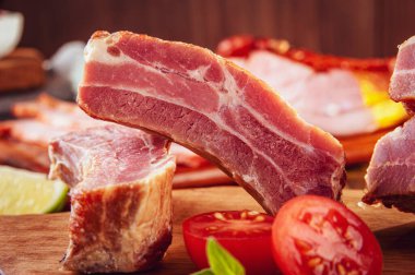 Tahtadaki çiğ Brezilya sosislerinde Linguica churrasco malzemeleri var.