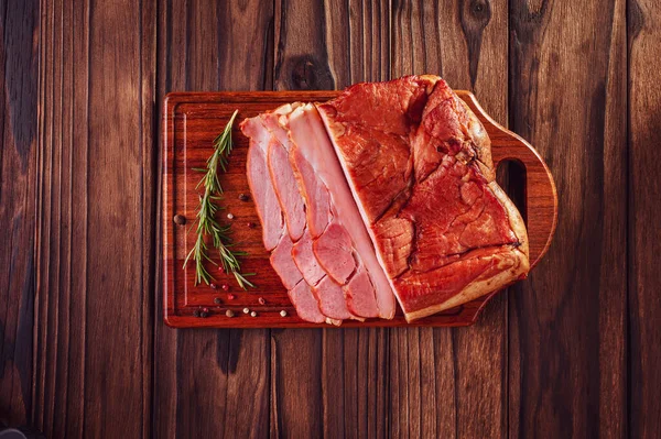 Biberiye dallı taze domuz pastırması ve ahşap arka planda izole edilmiş baharatlar.
