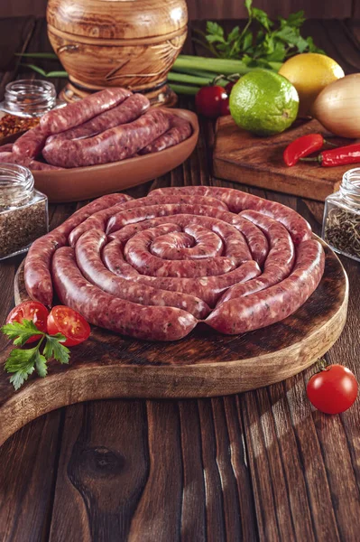 Tahtadaki çiğ Brezilya sosislerinde Linguica churrasco malzemeleri var.
