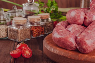 Tahtadaki çiğ Brezilya sosislerinde Linguica churrasco malzemeleri var.