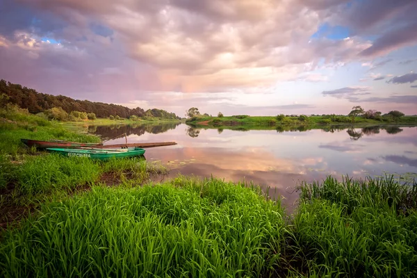 Picture of a row boat on Russian river Nerl on sunset. Blue sky and amazing clouds — Stock Image Picture of a row boat on Russian river Nerl on sunset. Blue sky and amazing clouds Stock Photo