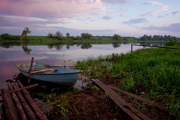 Picture of a row boat on Russian river Nerl on sunset. Blue sky and amazing clouds — Stock Image Picture of a row boat on Russian river Nerl on sunset. Blue sky and amazing clouds Stock Photo