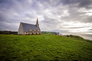 Fransa 'da Etretat köyü. Denizin manzarasını sunan kilisenin yakınında çift