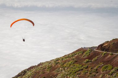 sarı çizgili yamaç paraşütü beyaz bulutlar, Tenerife, Teide ile gökyüzünde uçar kırmızı bir yamaç paraşütü