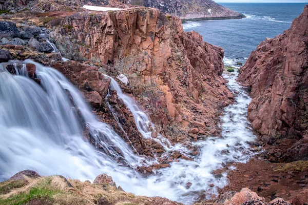 Águas tempestuosas da cachoeira do norte em um desfiladeiro rochoso nas margens do mar frio, Teriberka, Rússia — Fotografia de Stock