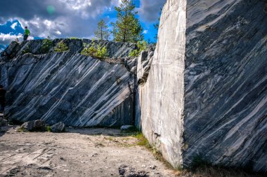 Çatlaklar ile mermer kaya. Mermer beyaz ve gri lekelerde. Ormanın etrafında. Ruskeala, Karelia.