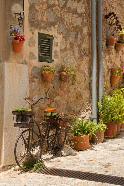Beautiful courtyard decorated with flower pots and ceramic tiles in Valdemossa, Majorka island, Spain.