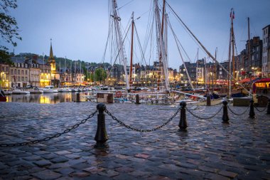 Akşamları Honfleur limanında taştan bir set ve yatlar.