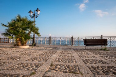 Costellamare del Golfo, Sicilya, İtalya 'daki gezinti güvertesinde boş bir bank. Yazın Tyren Denizi manzarası