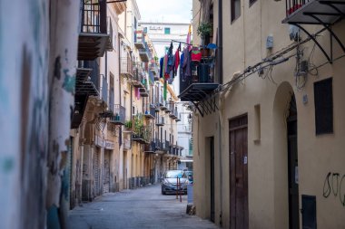 CEFALU, İTALYA - 29 EYLÜL 2019: Balkonları ve kıyafetleri olan eski bir kasaba sokağı