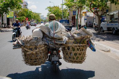 VUNG TAU, VİETNAM - 15 Mart 2013: Bir adam bisikletiyle çeşitli eşyalar taşıyor.