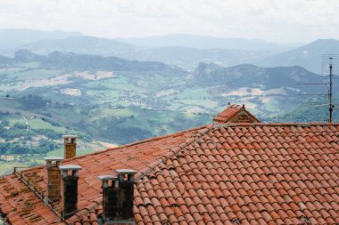 Eski seramik döşeme, çatı. San Marino Cumhuriyeti 'nin çevresinin manzarası. Baca, fırtına suyu, paratoner. Arka planda dağlar ve tarlalar. İtalya